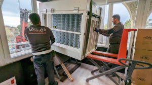 Imagen del equipo de Transportes Vela con una máquina emblistadora de medicamentos para una farmacia