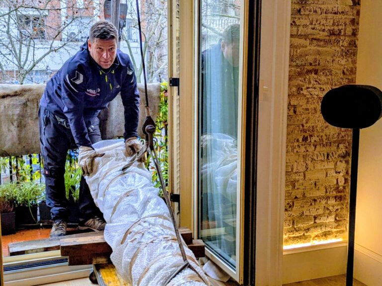 Movimiento e instalación de columna de mármol en vivienda de lujo en Alcalá de Henares mediante izado por ventana
